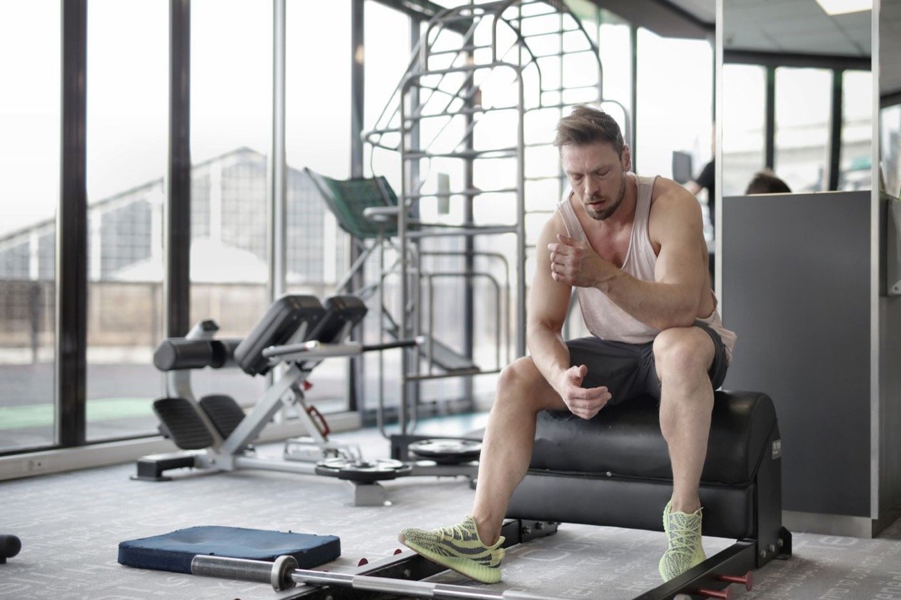 Athlete resting after a weightlifting workout in a gym