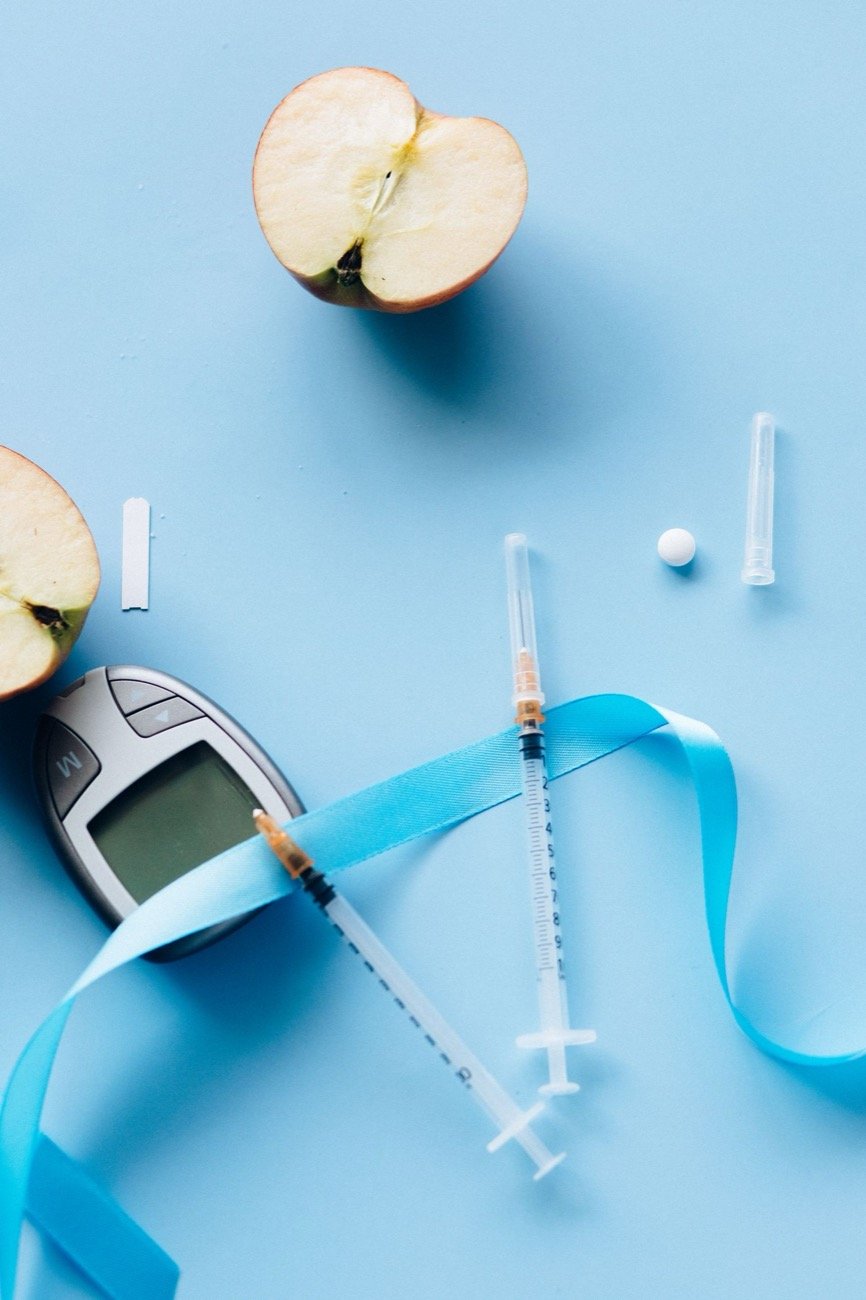 Blood sugar meter and syringe on a table