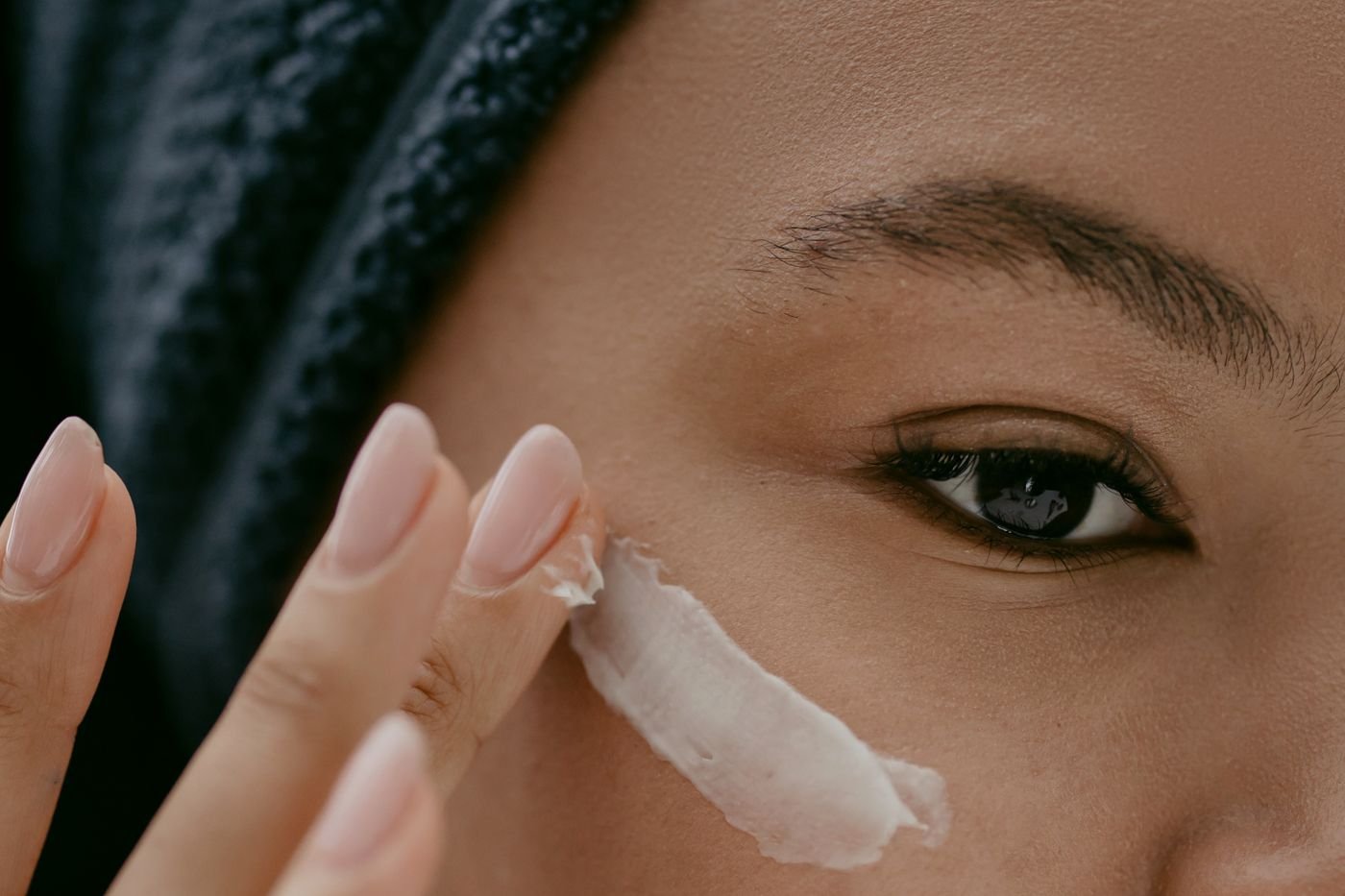Close-up of cream being applied to the skin under the eye